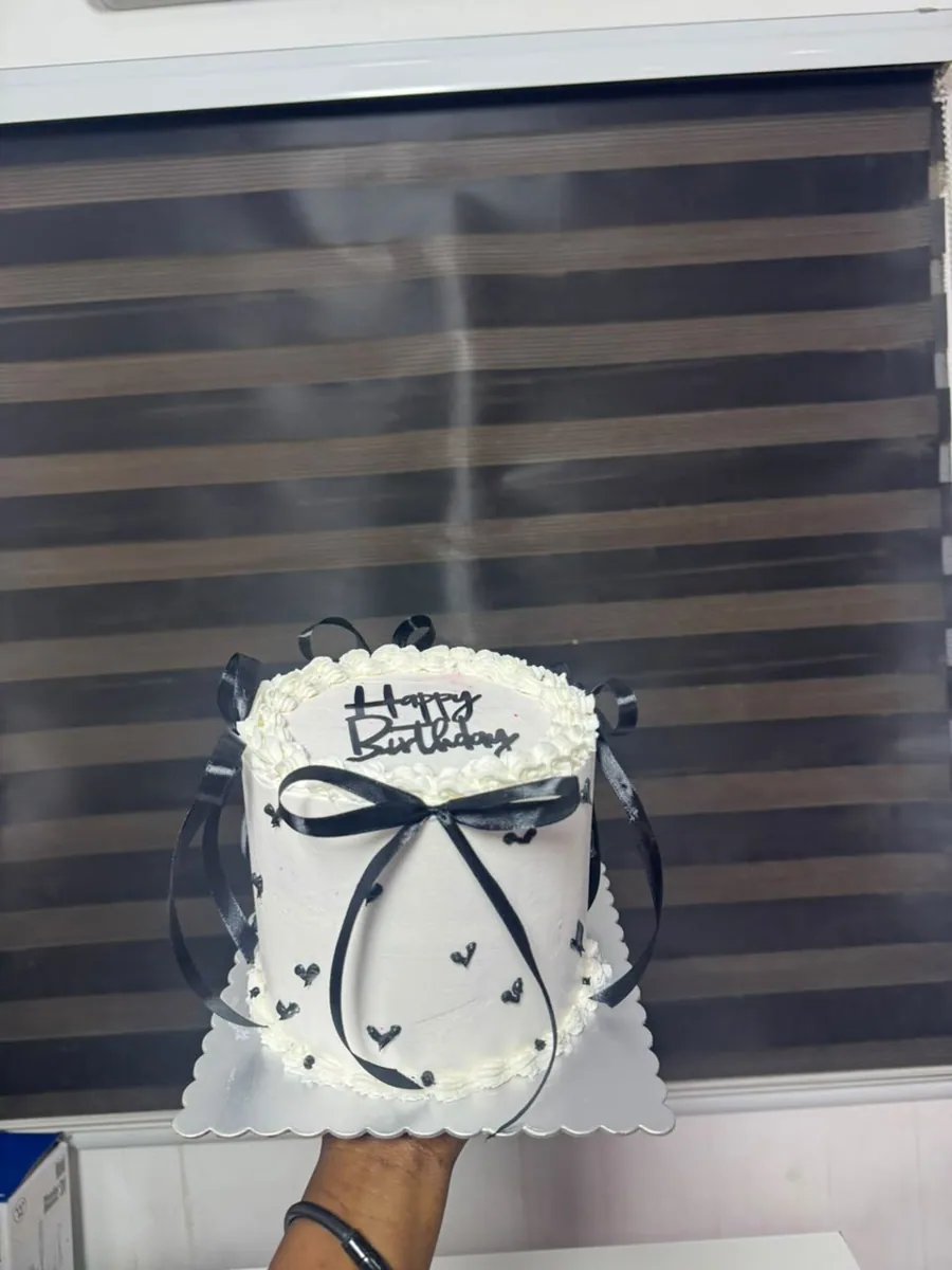 White birthday cake with black bows