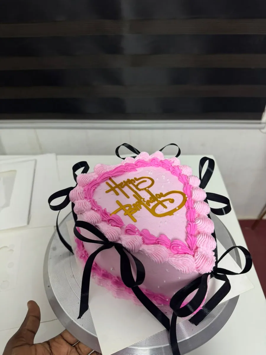 Pink heart birthday cake with black bows